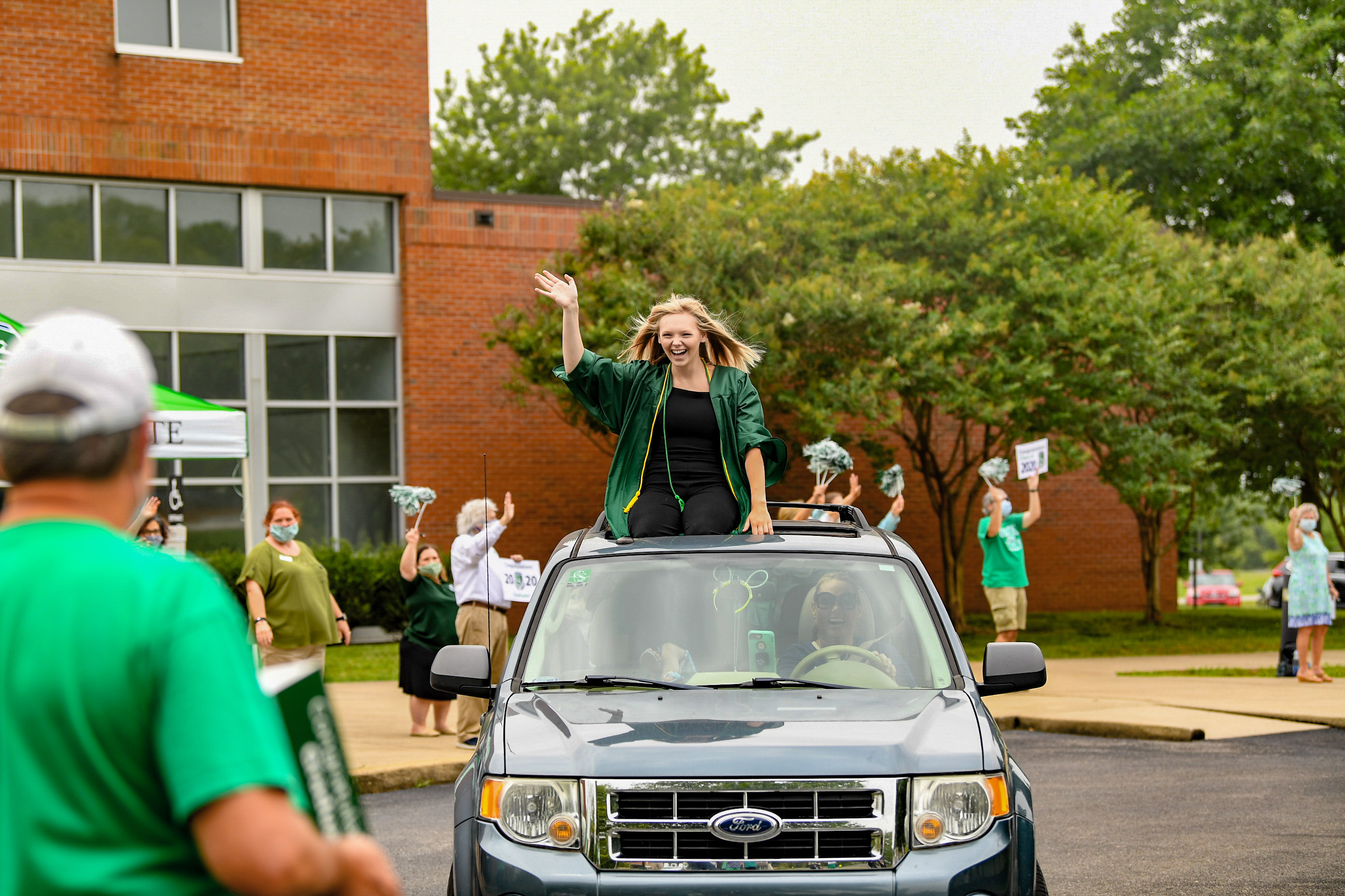 Jenna on top of a car waving