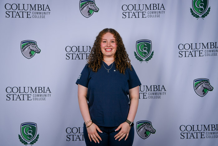 A person poses in front of a white background.