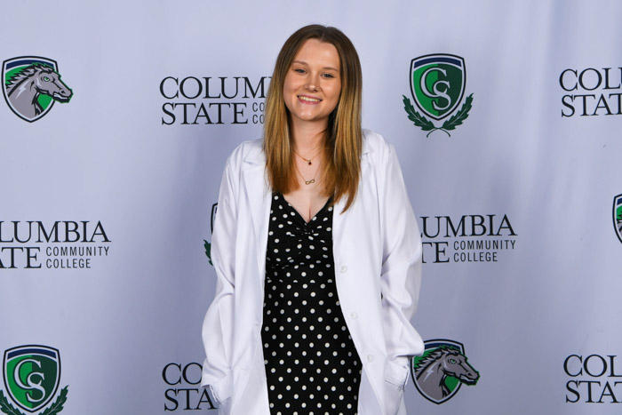 A person stands in front of a white background.