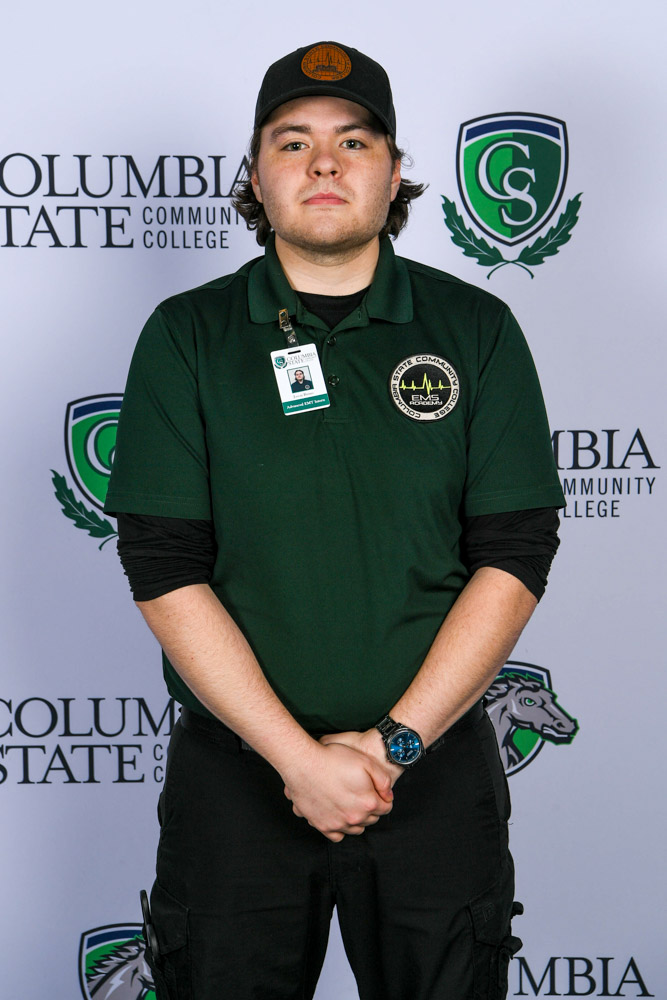 A man stands in front of a white background.