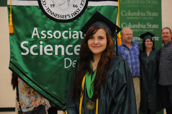 Female graduate in front of banner