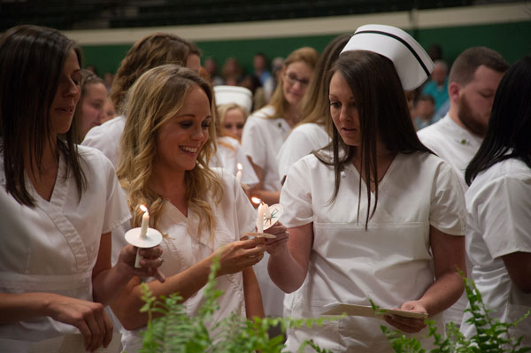 Girls light each other's candles