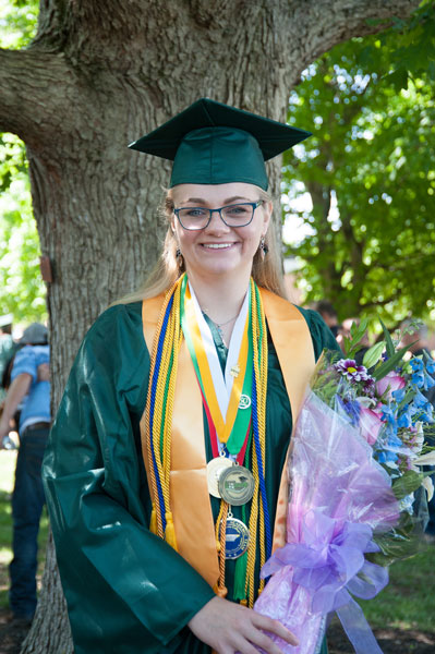 Blond girl in green cap and gown