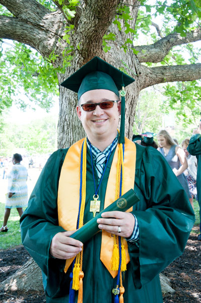 Guy in glasses with cap and gown